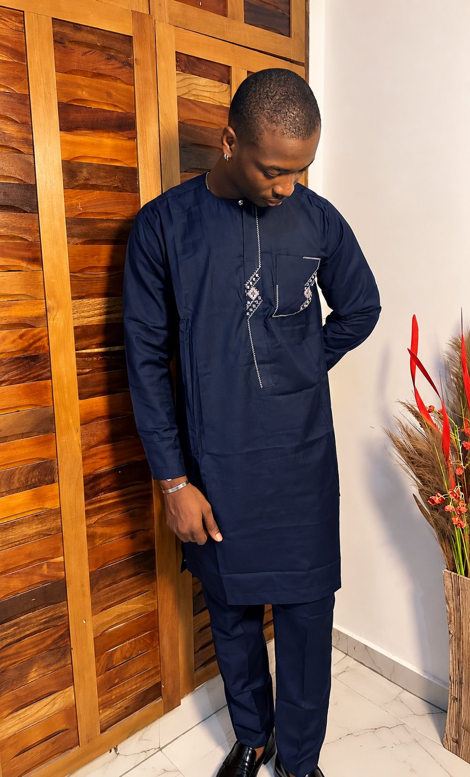Bleu marine, broderie crème en zigzag sur le plastron et la poche.