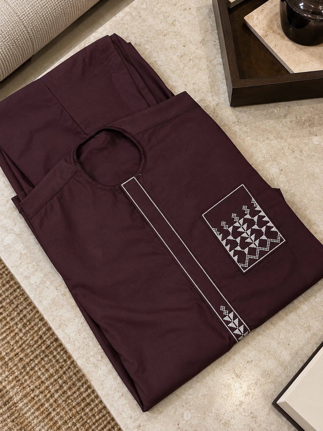Aubergine, motifs blancs brodés sur la poche et en bas du plastron.