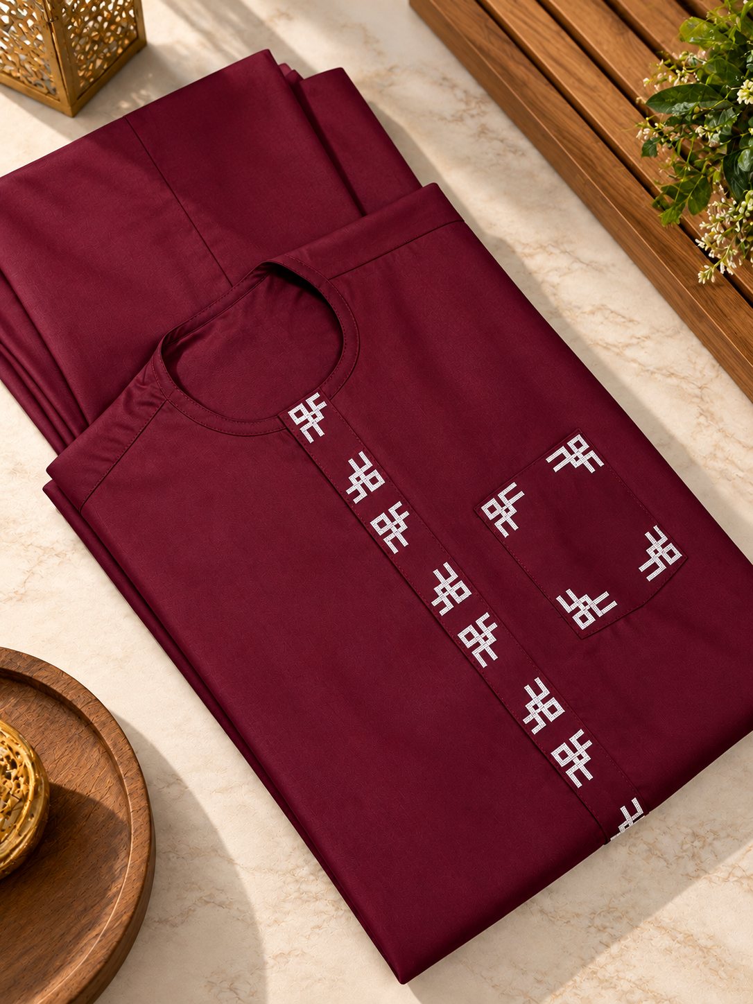 Bordeaux, motifs blancs brodés le long du plastron et autour de la poche.
