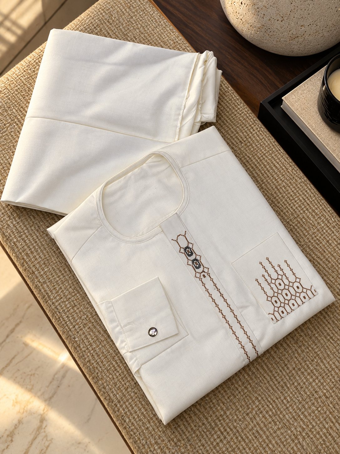 Ivoire, broderie géométrique brune et grise sur le plastron et la poche.